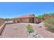 Back exterior view of the house showcases the well-kept desert landscaping and covered patio at 103 S Birdie Way, Casa Grande, AZ 85194