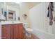 A bathroom featuring a shower with curtain, wood vanity, and toilet at 103 S Birdie Way, Casa Grande, AZ 85194