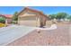 A desert landscaped driveway leads to the spacious two-car garage of this home at 103 S Birdie Way, Casa Grande, AZ 85194