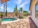 Backyard oasis featuring a freeform pool, mature palm trees, landscaped areas, and stone pathways at 10501 W Wilshire Dr, Avondale, AZ 85392