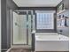 This bathroom features a soaking tub, glass block window, and a separate shower at 10501 W Wilshire Dr, Avondale, AZ 85392