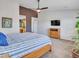 Bright bedroom with a ceiling fan, TV, and view into the bathroom space at 10501 W Wilshire Dr, Avondale, AZ 85392