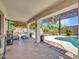 Spacious covered patio with tiled floor, comfortable seating, and views of the pool and landscaped backyard at 10501 W Wilshire Dr, Avondale, AZ 85392