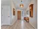 Open foyer featuring neutral tile flooring, a wooden front door, and a decorative ceiling light at 10501 W Wilshire Dr, Avondale, AZ 85392