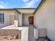 Welcoming covered entrance with a concrete path, desert landscaping, and textured exterior walls at 10501 W Wilshire Dr, Avondale, AZ 85392