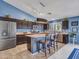 Open kitchen with stainless steel appliances, large island, and stylish lighting fixtures at 10501 W Wilshire Dr, Avondale, AZ 85392