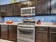Kitchen featuring stainless steel appliances, dark cabinets, and modern countertops at 10501 W Wilshire Dr, Avondale, AZ 85392
