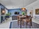 Open-concept living area with a dining table, modern lighting, and a view into the living room at 10501 W Wilshire Dr, Avondale, AZ 85392