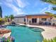 Beautiful backyard featuring a sparkling pool, covered patio and palm trees at 10501 W Wilshire Dr, Avondale, AZ 85392