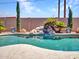 Gorgeous backyard featuring a pristine pool with a rock waterfall feature at 10501 W Wilshire Dr, Avondale, AZ 85392