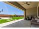A covered patio with a ceiling fan overlooks a beautiful backyard with artificial turf at 11015 E Texas Ave, Mesa, AZ 85212