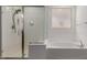 Bright bathroom features a bathtub and a glass-enclosed shower at 11015 E Texas Ave, Mesa, AZ 85212