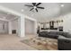 Spacious living area with open layout to kitchen, modern ceiling fan, and comfortable seating arrangement at 11015 E Texas Ave, Mesa, AZ 85212