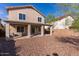 View of the backyard, featuring a covered patio, desert landscaping, rock ground cover, and a block wall at 118 N 223Rd Ave, Buckeye, AZ 85326