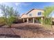 Large backyard featuring desert landscaping, covered patio, grass and trees at 118 N 223Rd Ave, Buckeye, AZ 85326