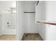 A combined view of the bathtub, tiled walls, and adjacent closet with clothes rack at 118 N 223Rd Ave, Buckeye, AZ 85326