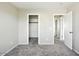 A bedroom with neutral walls and carpet, with an open closet with shelving and hanging rod at 118 N 223Rd Ave, Buckeye, AZ 85326