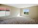Spacious carpeted bedroom with two windows providing natural light and views at 118 N 223Rd Ave, Buckeye, AZ 85326