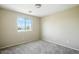 Neutral bedroom featuring a window that allows natural light, complemented by carpeted floors at 118 N 223Rd Ave, Buckeye, AZ 85326