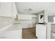 Well-lit kitchen featuring tile flooring, white cabinets, and a breakfast bar at 118 N 223Rd Ave, Buckeye, AZ 85326
