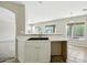 Open-concept kitchen featuring tile flooring, white cabinets, and a breakfast bar at 118 N 223Rd Ave, Buckeye, AZ 85326