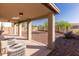 Covered patio featuring stone pillars, a ceiling light, desert landscaping, and rock ground cover at 118 N 223Rd Ave, Buckeye, AZ 85326