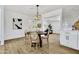 Bright dining area features hardwood floors, modern chandelier, and is open to the living spaces at 132 W Orchid Ln, Chandler, AZ 85225