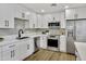 A well-lit kitchen featuring stainless steel appliances, white cabinets, and modern fixtures at 132 W Orchid Ln, Chandler, AZ 85225
