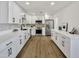 Bright kitchen with white cabinets, stainless steel appliances, and wood flooring creating an inviting culinary space at 132 W Orchid Ln, Chandler, AZ 85225