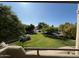 Balcony with view of the manicured lawn, mature trees, and ample parking, offering a serene and convenient living environment at 1825 W Ray Rd # 2082, Chandler, AZ 85224