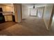 Open-concept living room with neutral carpet and adjacent kitchen, perfect for modern living and entertaining guests at 1825 W Ray Rd # 2082, Chandler, AZ 85224