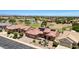 Bird's eye view of a desert home with solar panels, golf course, and a serene pond at 19745 N Mountain Sage Ln, Surprise, AZ 85374