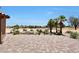 View of a spacious brick patio with desert landscaping and palm trees overlooking the golf course at 19745 N Mountain Sage Ln, Surprise, AZ 85374