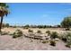 A backyard patio with a water feature is landscaped with desert plants, rocks and colorful pavers at 19745 N Mountain Sage Ln, Surprise, AZ 85374