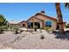 Charming backyard featuring desert landscaping, tiled patio, and a stucco home exterior at 19745 N Mountain Sage Ln, Surprise, AZ 85374