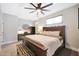 Comfortable bedroom with a wooden bed frame, ceiling fan, and lots of natural light at 19745 N Mountain Sage Ln, Surprise, AZ 85374