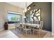 Bright dining room with a modern chandelier and an open view of the manicured outdoor space at 19745 N Mountain Sage Ln, Surprise, AZ 85374