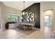 Elegant dining room with a large window view, modern lighting, and dark accent wall at 19745 N Mountain Sage Ln, Surprise, AZ 85374