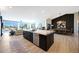 Modern kitchen with stainless appliances, center island with sink, and open view to the dining and living area at 19745 N Mountain Sage Ln, Surprise, AZ 85374