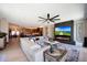 Comfortable living room featuring a stone fireplace, television, hardwood floors, and lots of natural light at 19745 N Mountain Sage Ln, Surprise, AZ 85374