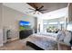 Bright main bedroom featuring a custom ceiling, television, and a sitting area at 19745 N Mountain Sage Ln, Surprise, AZ 85374