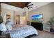 Main bedroom with custom wood-slat ceiling, television, and view into the bathroom at 19745 N Mountain Sage Ln, Surprise, AZ 85374