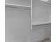 A walk-in closet with white shelving and metal hanging rods for storage at 28848 W Grand Ave, Wittmann, AZ 85361