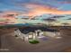 Stunning single-story home featuring a neutral palette, dark roof, and desert landscaping at twilight at 28848 W Grand Ave, Wittmann, AZ 85361