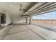 View of a large, clean garage with an open overhead door and views of the surrounding desert landscape at 28848 W Grand Ave, Wittmann, AZ 85361