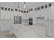 Bright kitchen boasts white cabinets, quartz counters, stainless appliances, and pendant lights at 28848 W Grand Ave, Wittmann, AZ 85361