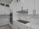 Bright kitchen boasts white cabinets, quartz counters and backsplash, and stainless appliances at 28848 W Grand Ave, Wittmann, AZ 85361