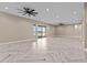 Bright living room boasting herringbone floors, ceiling fan, and sliding glass doors to the backyard at 28848 W Grand Ave, Wittmann, AZ 85361