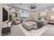 Cozy main bedroom offers a ceiling fan, plush carpet, neutral tones, a large window, and tastefully designed decor at 28848 W Grand Ave, Wittmann, AZ 85361