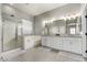 Bright bathroom featuring dual sinks, granite counters, a tub, and a glass-enclosed shower at 3006 E Lexington Ave, Gilbert, AZ 85234